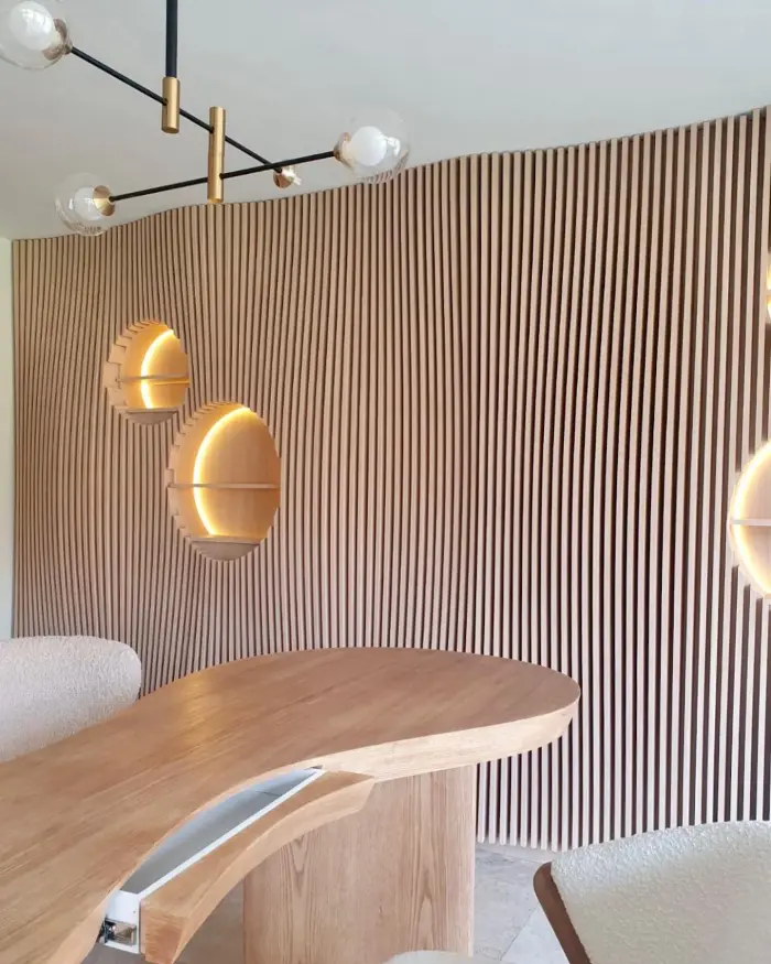 Consultorio Auri — pared de lambín de madera con nichos iluminados